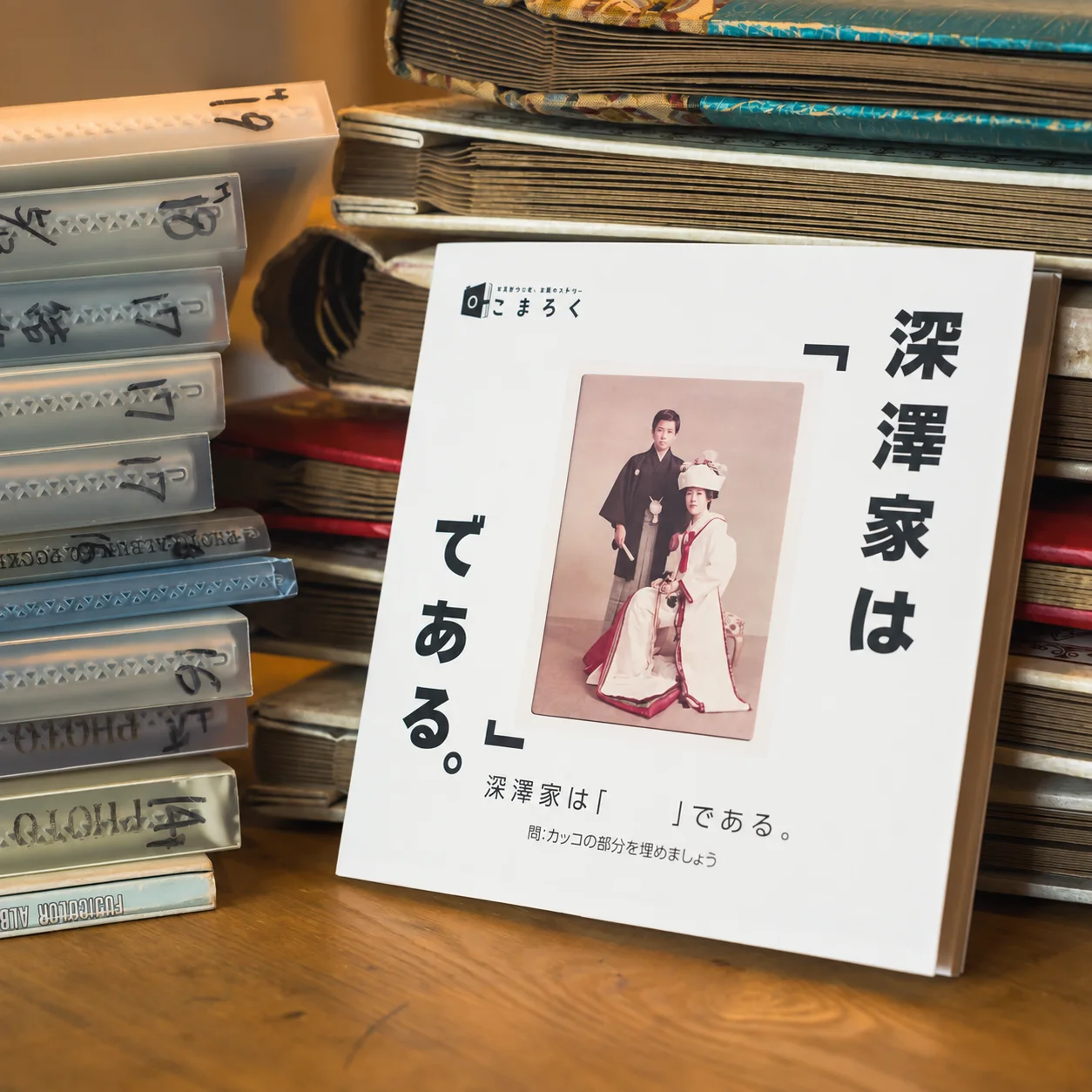 昔のアルバムの前に置かれた、家族の写真を表紙にしたフォトブック